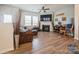 Comfortable living room featuring hardwood flooring, a fireplace, and cozy seating perfect for relaxing at 5391 Orchid Bloom Dr, Indian Land, SC 29707