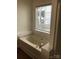 Bright bathroom featuring a soaking tub beneath a window bringing in natural light and view to the outdoors at 5508 Burning Ridge Dr, Monroe, NC 28110