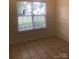 Bedroom showcasing neutral walls, tile flooring, and a large window providing ample natural light and neighborhood views at 5508 Burning Ridge Dr, Monroe, NC 28110