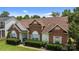 Classic brick home with a well-maintained lawn, mature landscaping, and arched windows at 5508 Burning Ridge Dr, Monroe, NC 28110