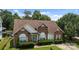 Charming brick home featuring arched windows, manicured landscaping, and a lush green lawn at 5508 Burning Ridge Dr, Monroe, NC 28110