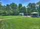 Manicured backyard features a well-maintained lawn, a gazebo, outdoor seating, and mature trees at 5921 Meadowmere Dr, Monroe, NC 28110