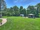 Manicured backyard features a well-maintained lawn, a gazebo, outdoor seating, and mature trees at 5921 Meadowmere Dr, Monroe, NC 28110