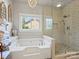 Bright bathroom features soaking tub, glass shower, and backyard view at 5921 Meadowmere Dr, Monroe, NC 28110