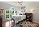 Sunlit bedroom with large window, hardwood floors, and ceiling fan at 5921 Meadowmere Dr, Monroe, NC 28110