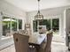 Dining area with a wooden table, tufted chairs, and abundant natural light through large windows at 5921 Meadowmere Dr, Monroe, NC 28110