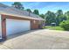 Brick home exterior showcasing a two-car garage and a landscaped backyard with gazebo at 5921 Meadowmere Dr, Monroe, NC 28110