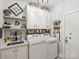 Functional laundry room with sink, washer, dryer, and custom shelving at 5921 Meadowmere Dr, Monroe, NC 28110