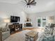 Open living room with fireplace, TV, and a decorative ceiling fan, providing ample natural light at 5921 Meadowmere Dr, Monroe, NC 28110