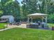 Charming backyard patio with gazebo, outdoor seating, fire pit, string lights, and lush greenery at 5921 Meadowmere Dr, Monroe, NC 28110
