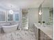 Bright bathroom featuring a soaking tub, marble floors, glass shower, and a spacious vanity at 6314 Saint Stephen Ln, Charlotte, NC 28210