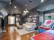 Bonus room featuring a large sectional, wet bar, hardwood floors, and ample space for entertaining at 6314 Saint Stephen Ln, Charlotte, NC 28210