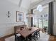 Elegant dining room with large windows, wood table and chairs, and modern chandelier at 6314 Saint Stephen Ln, Charlotte, NC 28210