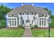 Beautiful white painted brick home with arched door, stone details, and manicured front lawn at 6314 Saint Stephen Ln, Charlotte, NC 28210