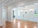 Bright hallway with hardwood floors, designer wallpaper, and arched doorway to the main front door at 6314 Saint Stephen Ln, Charlotte, NC 28210