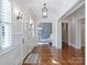 Inviting hallway with hardwood floors, designer wallpaper, archway to office, and modern light fixtures at 6314 Saint Stephen Ln, Charlotte, NC 28210