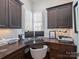 Cozy home office with custom built-ins, wooden desk, and natural light from large windows at 6314 Saint Stephen Ln, Charlotte, NC 28210