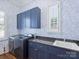 Well-organized laundry room with blue cabinetry, granite counters, and modern appliances at 6314 Saint Stephen Ln, Charlotte, NC 28210
