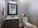 Stylish powder room featuring marble vanity, a modern sink, and unique wallpaper at 6314 Saint Stephen Ln, Charlotte, NC 28210
