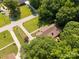 An aerial view shows the house with mature trees, green grass, and lovely landscaping surrounded by a wood fence at 637 Freemont Dr, Lancaster, SC 29720