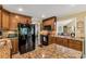 Open concept kitchen with granite countertops, wood cabinets, and black appliances at 637 Freemont Dr, Lancaster, SC 29720