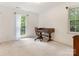 Bright bedroom featuring white walls, neutral carpet, and a vintage wooden desk with a window view at 7118 Powder Mill Pl, Charlotte, NC 28277