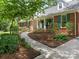 Well-maintained brick home with walkway, mature landscaping, and covered front porch at 7118 Powder Mill Pl, Charlotte, NC 28277