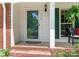 Inviting front porch with brick steps, white columns, and green shutters at 7118 Powder Mill Pl, Charlotte, NC 28277
