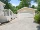 Detached two car garage featuring a white garage door with adjacent white staircase at 7118 Powder Mill Pl, Charlotte, NC 28277