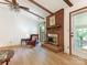 Inviting living room with a brick fireplace, beamed ceiling, and hardwood floors at 7118 Powder Mill Pl, Charlotte, NC 28277