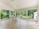 Light-filled sunroom with tile flooring, ceiling fan, and walls of windows overlooking the backyard at 7118 Powder Mill Pl, Charlotte, NC 28277