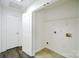 Bright laundry room with tile floor, a utility sink, and a door to the outside at 722 Overlook Rd, Lowell, NC 28098