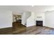 View of the living room, stairs and kitchen featuring hard surface floors, neutral paint and a gas fireplace at 722 Overlook Rd, Lowell, NC 28098