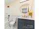 Bathroom featuring a shower and tub combo, vanity with marble countertop, and a round mirror at 803 Irene Ave, Kannapolis, NC 28083