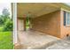 Spacious covered carport adjacent to the brick house with door and brick wall at 1019 Carmel Dr, Gastonia, NC 28056