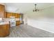 View of the kitchen with white appliances, updated floor and wood cabinets at 1019 Carmel Dr, Gastonia, NC 28056