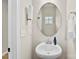 A quaint powder room with a pedestal sink, oval mirror, and neutral decor provides a clean and simple design at 11195 Argosy Dr # 1098, Lancaster, SC 29720
