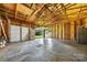 Large garage interior, featuring high ceiling, concrete floor and door with access to the backyard at 1122 Oconee Ave, Rock Hill, SC 29732