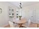 Bright dining area with a modern chandelier, table, white chairs, and natural light at 1223 E 16Th St # 13, Charlotte, NC 28205