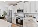 Bright kitchen with stainless steel appliances, white cabinets and backsplash, and hardwood floors at 1223 E 16Th St # 13, Charlotte, NC 28205