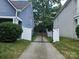 A view of a backyard that features a black iron gate, sidewalk, and privacy fence at 1226 Rising Oak Dr, Charlotte, NC 28206