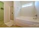 Bright bathroom featuring a tub and separate glass shower with tile floor at 1226 Rising Oak Dr, Charlotte, NC 28206