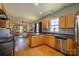 Open-concept kitchen with breakfast bar, stainless appliances and hardwood floors, leading to living area at 1226 Rising Oak Dr, Charlotte, NC 28206