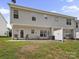Townhome backyard featuring a small patio, grass, and trees at 12415 Stratfield Place Cir, Pineville, NC 28134