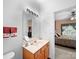 Bathroom featuring a large mirror, vanity, and a view into the bedroom with a ceiling fan at 12415 Stratfield Place Cir, Pineville, NC 28134