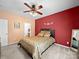 Comfortable bedroom with neutral carpet, ceiling fan, accent wall, and a view to the en suite bathroom at 12415 Stratfield Place Cir, Pineville, NC 28134