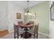 Charming dining area features a round wood table, four chairs, decorative chandelier and neutral wall color at 12415 Stratfield Place Cir, Pineville, NC 28134