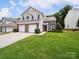 Two-story townhome featuring a well-maintained lawn and a two-car garage at 12415 Stratfield Place Cir, Pineville, NC 28134