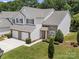 Aerial view of a two-story townhome with a two-car garage and manicured landscaping at 12415 Stratfield Place Cir, Pineville, NC 28134