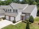 Aerial view of a two-story townhome with a two-car garage and manicured landscaping at 12415 Stratfield Place Cir, Pineville, NC 28134